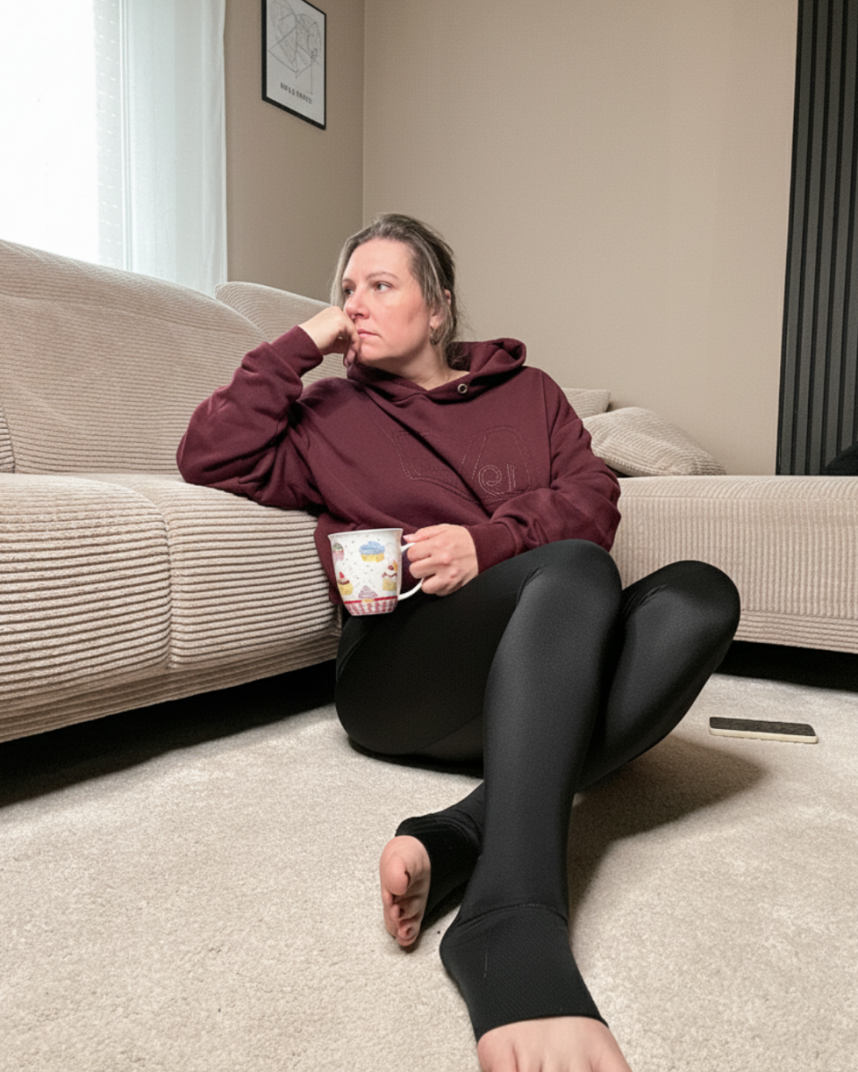 Lipödem Heldin Lyn sitzt auf dem Boden und trägt dabei die TBfLg leggings von LIPOELASTIC